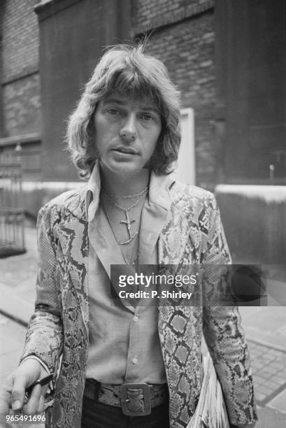 American singer John Christian Dee pictured wearing a snakeskin jacket and belt in London on 12th July 1973. John Christian Dee is the husband of...