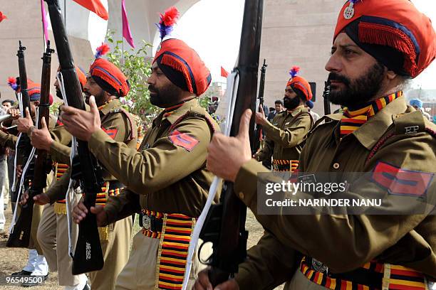 Indian Punjab police personnel presents arms as they pay tribute at the memorial of the Sikh warrior General Sardar Sham Singh Attari at India Gate...
