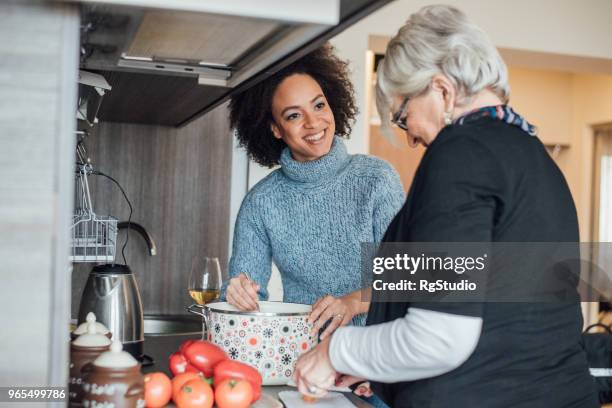 older and younger woman preparing a meal together - mother daughter cooking stock pictures, royalty-free photos & images