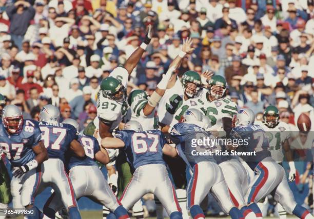 Marvin Washington,Paul Frase and Jeff Lageman, Defensive Linemen for the New York Jets jump to try to block a kick from Matt Bahr of the New England...