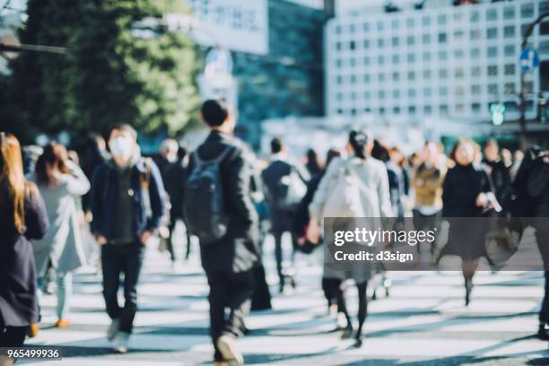 busy commuters crossing street in downtown district during office rush hours - japanese culture fotografías e imágenes de stock