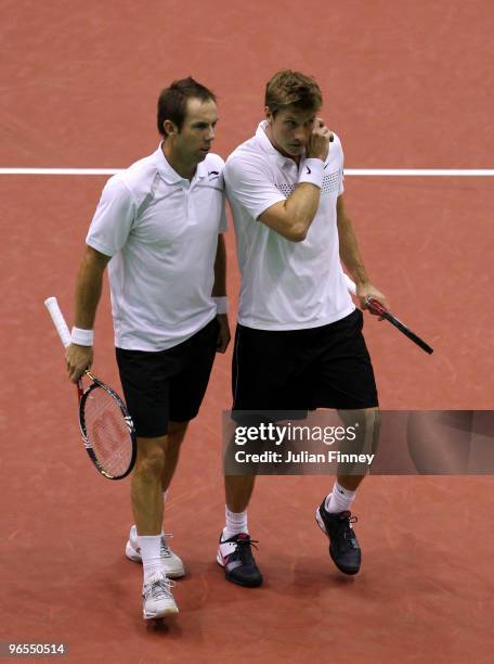 Simon Aspelin of Sweden and Paul Hanley of Australia talk tactics during their first round doubles match against Simone Bolelli and Andreas Seppi of...