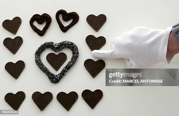 Employee of the Dutch company Koek and Chocolade in Laren, points out fresh chocolates ahead of St Valentine's day on February 10, 2010. Chocolates...