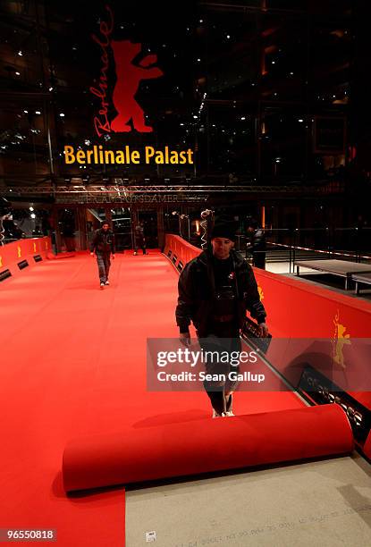 Worker unrolls the red carpet in front of the Berlinale Palast, the main venue at the 60th Berlinale International Film Festival, on February 10,...
