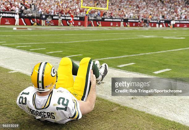 Aaron Rodgers of the Green Bay Packers stretches from on the sidelines before the game against the Arizona Cardinals in the NFC wild-card playoff...