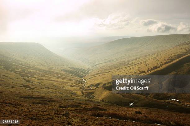 Sunlight breaks through the mist in cold conditions looking South West from the mountain 'Corn Du' in the Brecon Beacons National Park on February 6,...