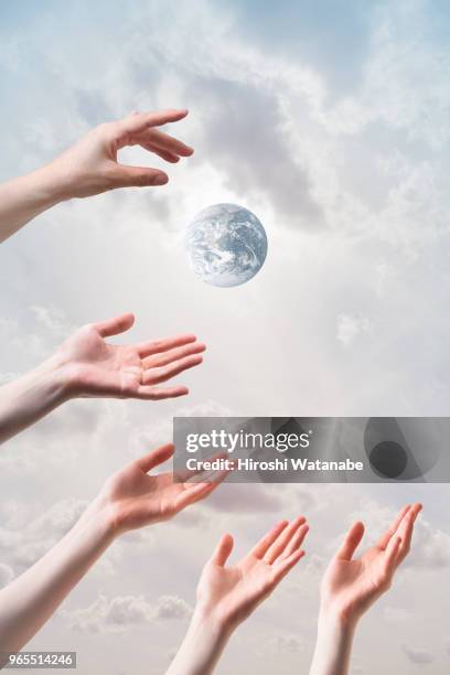 hands seem to reach  the another earth - composite bonding stock pictures, royalty-free photos & images