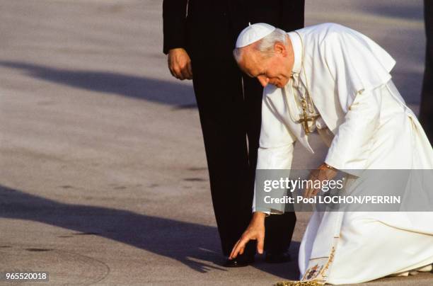 Le pape Jean-Paul II touche le sol lors de son arrivée le 31 octobre 1982 à Madrid, Espagne.