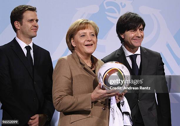 German Chancellor Angela Merkel receives the German FIFA World Cup 2010 jersey 'Teamgeist' by Head coach Joachim Loew of the German football national...