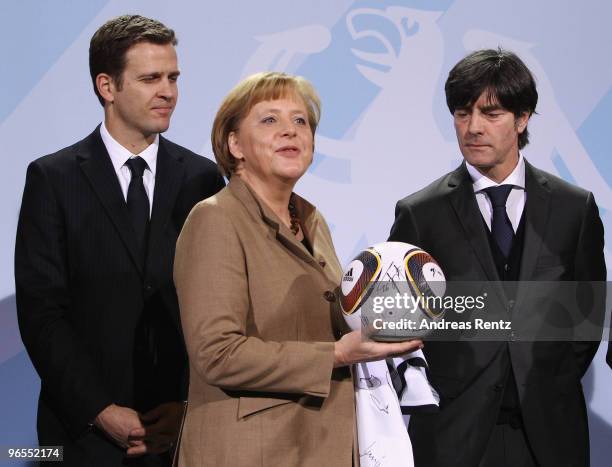 German Chancellor Angela Merkel receives the German FIFA World Cup 2010 jersey 'Teamgeist' by Head coach Joachim Loew of the German football national...