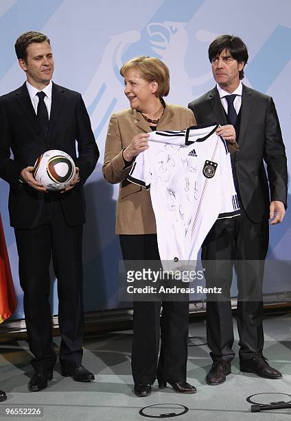 German Chancellor Angela Merkel receives the German FIFA World Cup 2010 jersey 'Teamgeist' by Head coach Joachim Loew of the German football national...