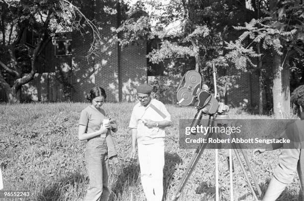 Fisk University film program student Gloria Brown and director Carlton Moss , in white, confer on a scene during filming in Nashville, TN, 1972.