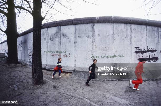 Enfants courant devant le mur de Berlin, en Allemagne de l'Ouest le 15 mai 1984.