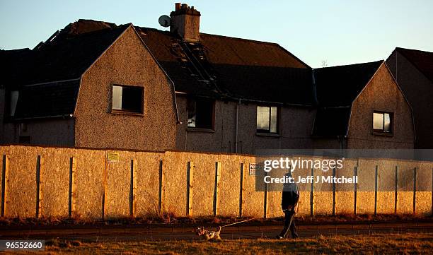 Man walks his dog past boarded up houses in the village of Lochore, in the constituency of Gordon Brown, British Prime minister on February 10, 2010...
