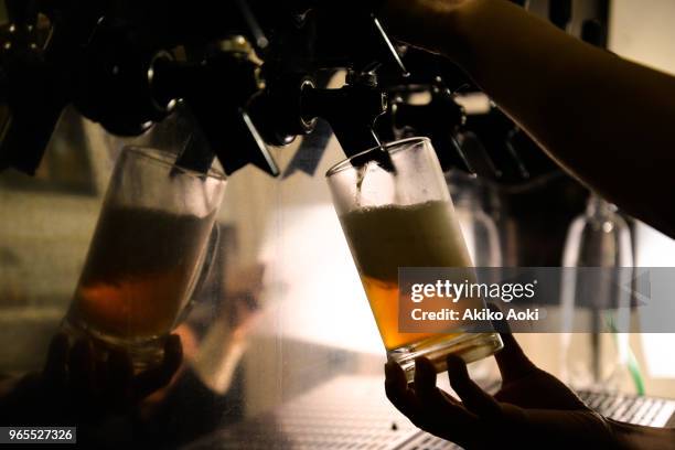 beer mug and hands pouring beer on tap - beer tap stockfoto's en -beelden