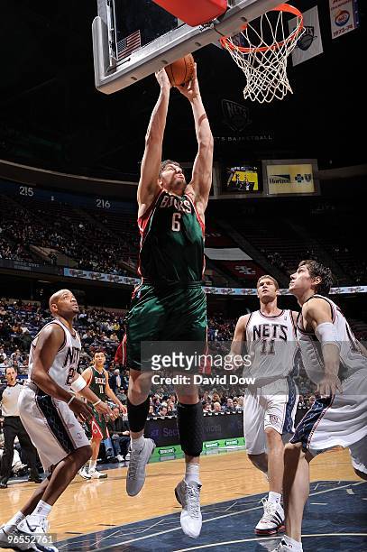 Andrew Bogut of the Milwaukee Bucks shoots against Jarvis Hayes and Eduardo Najera of the New Jersey Nets during the game on January 5, 2010 at the...