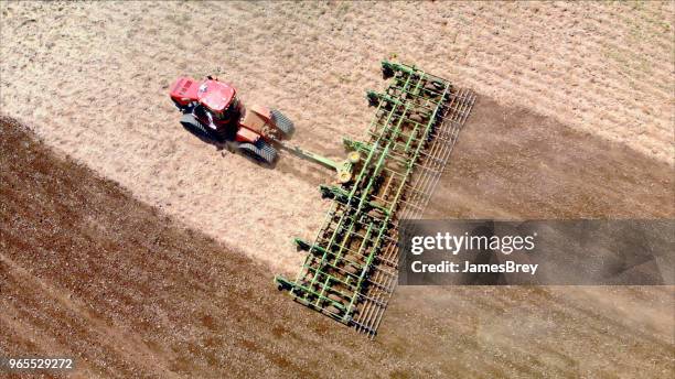 big farm tractor tilling dusty springtime fields. - establishing shot stock pictures, royalty-free photos & images