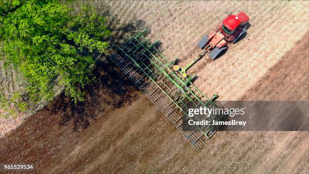 big farm tractor tilling dusty springtime fields. - establishing shot stock pictures, royalty-free photos & images