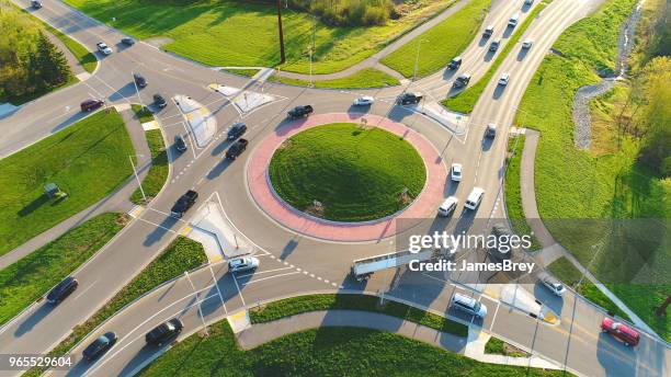 busy city roundabout intersection at sunrise rush hour. - roundabout stock pictures, royalty-free photos & images