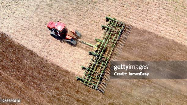 big farm tractor tilling dusty springtime fields. - establishing shot stock pictures, royalty-free photos & images