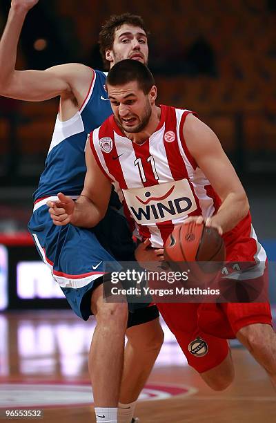 Linas Kleiza, #11 of Olympiacos Piraeus competes with Luksa Andric, #12 of KK Cibona Zagreb during the Euroleague Basketball 2009-2010 Last 16 Game 3...