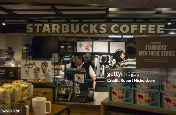 Employees at a Starbucks store serve customers May 15, 2018 at a rest stop along the New York State Thruway in Saugerties, New York. Starbucks stores...