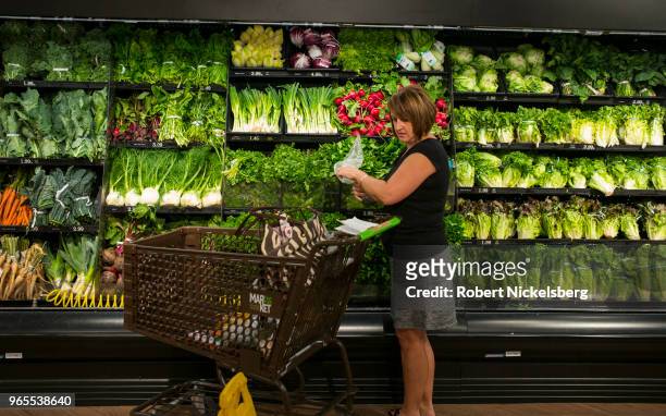 Woman shops for fresh vegetables May 21, 2018 at the Price Chopper supermarket in South Burlington, Vermont. Price Chopper is a chain of supermarkets...