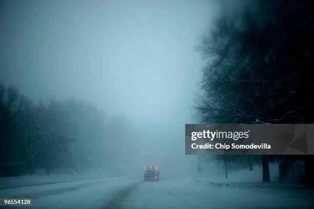 An ambulance drives down the road as it drives through the blowing snow during a powerful winter storm February 10, 2010 in Washington, DC. The...