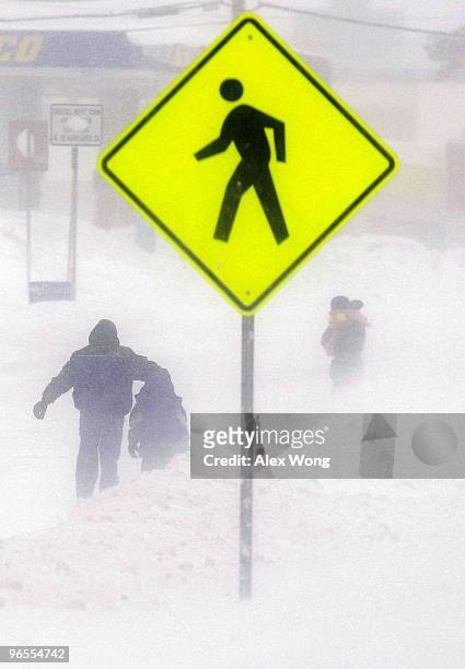 Pedestrians walk in a white-out situation during a snowstorm February 10, 2010 in Alexandria, Virginia. A second snowstorm is hitting the Washington,...