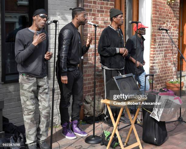 Black doo-wop group sings for tips along a sidewalk in the Old Town section of Alexandria, Virginia.