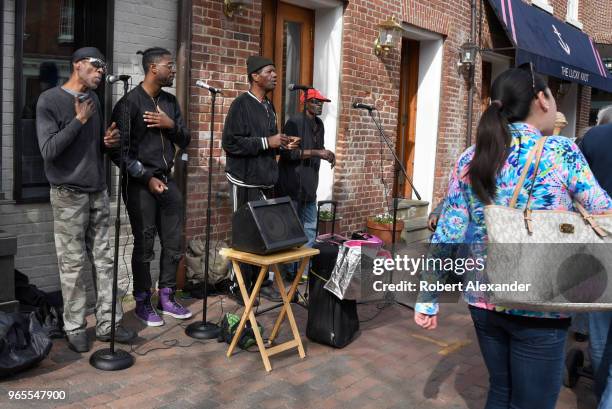 Black doo-wop group sings for tips along a sidewalk in the Old Town section of Alexandria, Virginia.