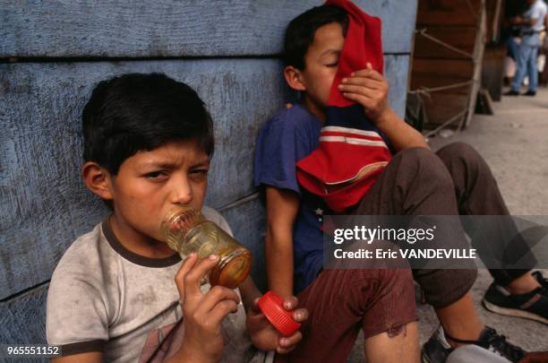 Jeunes garçons vivant dans la rue se droguant à l'aide de colle en décembre 1990 à Guatemala City, Guatemala.