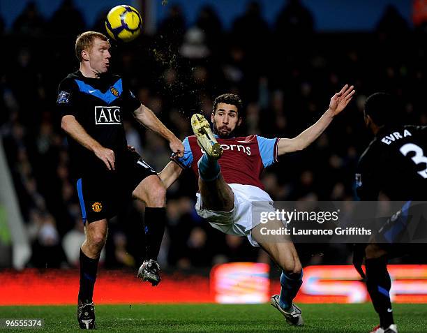 Carlos Cuellar of Aston Villa battles for the ball with Paul Scholes of Manchester United during the Barclays Premier League match between Aston...
