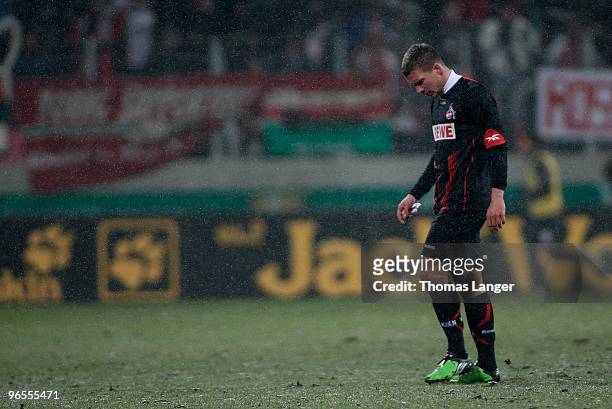 Lukas Podolski of cologne leaves the pitch after receiving the red card during the DFB Cup quarterfinal match between FC Augsburg and FC Koeln at the...