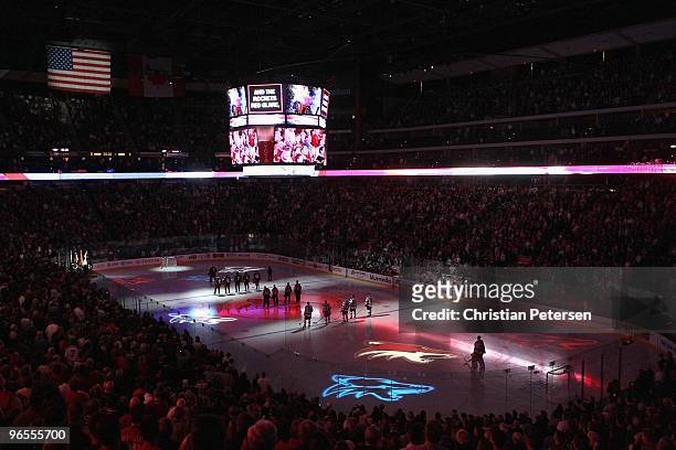 The New York Rangers and the Phoenix Coyotes stand attended for the National Anthem prior to the NHL game at Jobing.com Arena on January 30, 2010 in...