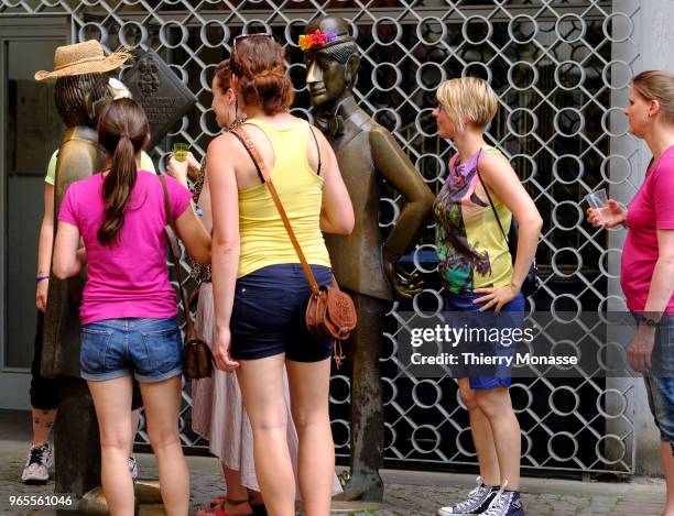 Girls have fun with the statue of Tunnes und Schal during a Bachelorette party. Tuennes and Schael are two legendary figures from the Hänneschen...