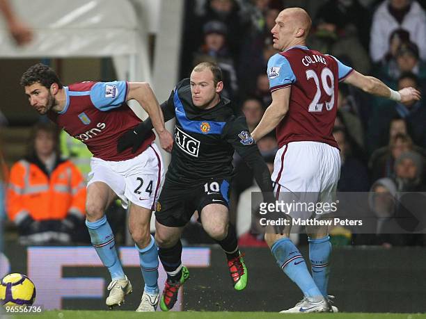 Wayne Rooney of Manchester United clashes with Carlos Cuellar and James Collins of Aston Villa during the FA Barclays Premier League match between...