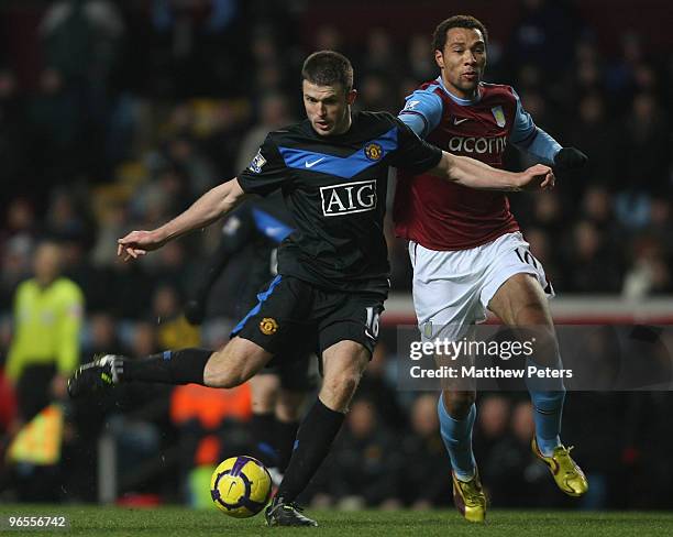 Michael Carrick of Manchester United clashes with John Carew of Aston Villa during the FA Barclays Premier League match between Aston Villa and...