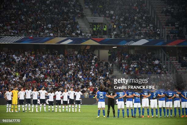 France's players and Italy's players stand in lines during a homage to late French football player Roger Piantoni who died on May 26, before the...