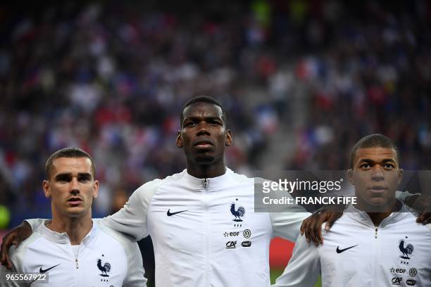 France's foward Antoine Griezmann, France's midfielder Paul Pogba and France's foward Kylian Mbappe stand in a line before the friendly football...