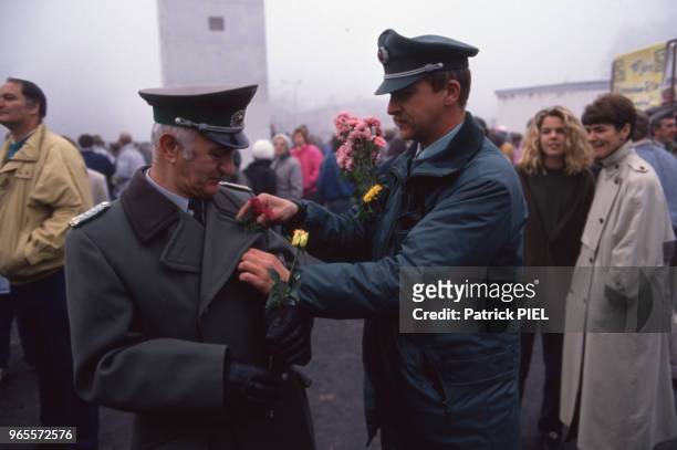 Offiicers ouest-allemands avec une fleur à leur boutonnière après la chute du mur de Berlin le 13 novembre 1989, Allemagne.