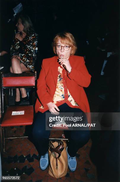 Josiane Balasko patiente avec une sucette avant d'assister au défilé Jean-Paul Gaultier Prêt-à-Porter Printemps-Eté 98 le 16 octobre 1997 à Paris,...