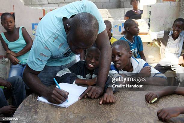 In this handout photo provided by UN PHOTO, members of OJADH open a Kantin, or a small restaurant, to feed children in Bel Air free of charge on...