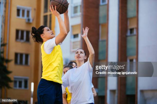 women taking a shot for the win - woman yellow basketball stock pictures, royalty-free photos & images