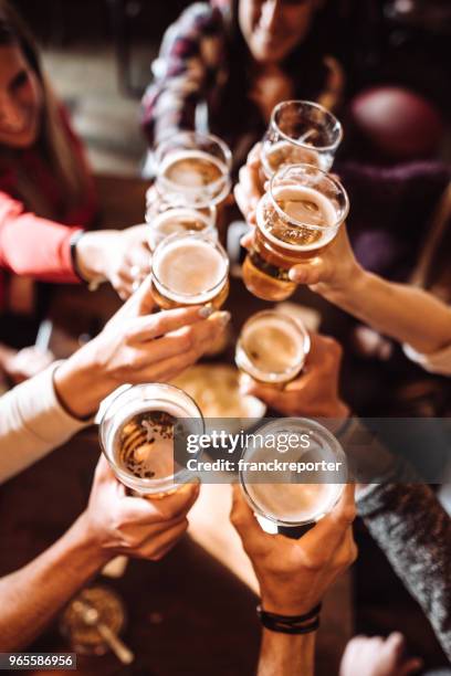 gens qui parlent le grillage dans un pub avec les bières - beer bar photos et images de collection