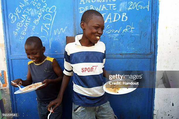 In this handout photo provided by UN PHOTO, members of OJADH open a Kantin, or a small restaurant, to feed children in Bel Air free of charge on...