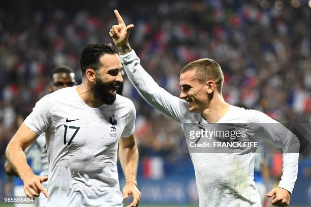 France's foward Antoine Griezmann celebrates with France's defender Adil Rami after scoring a penalty kick during the friendly football match between...
