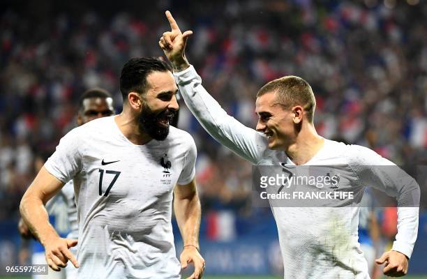 France's foward Antoine Griezmann celebrates with France's defender Adil Rami after scoring a penalty kick during the friendly football match between...