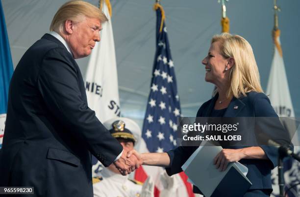 President Donald Trump shakes hands with Secretary of Homeland Security Kirstjen Nielsen during a Change of Command ceremony as Admiral Karl Schultz...