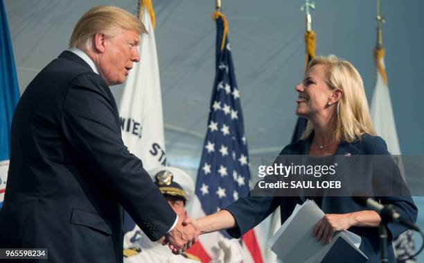 President Donald Trump shakes hands with Secretary of Homeland Security Kirstjen Nielsen during a Change of Command ceremony as Admiral Karl Schultz...